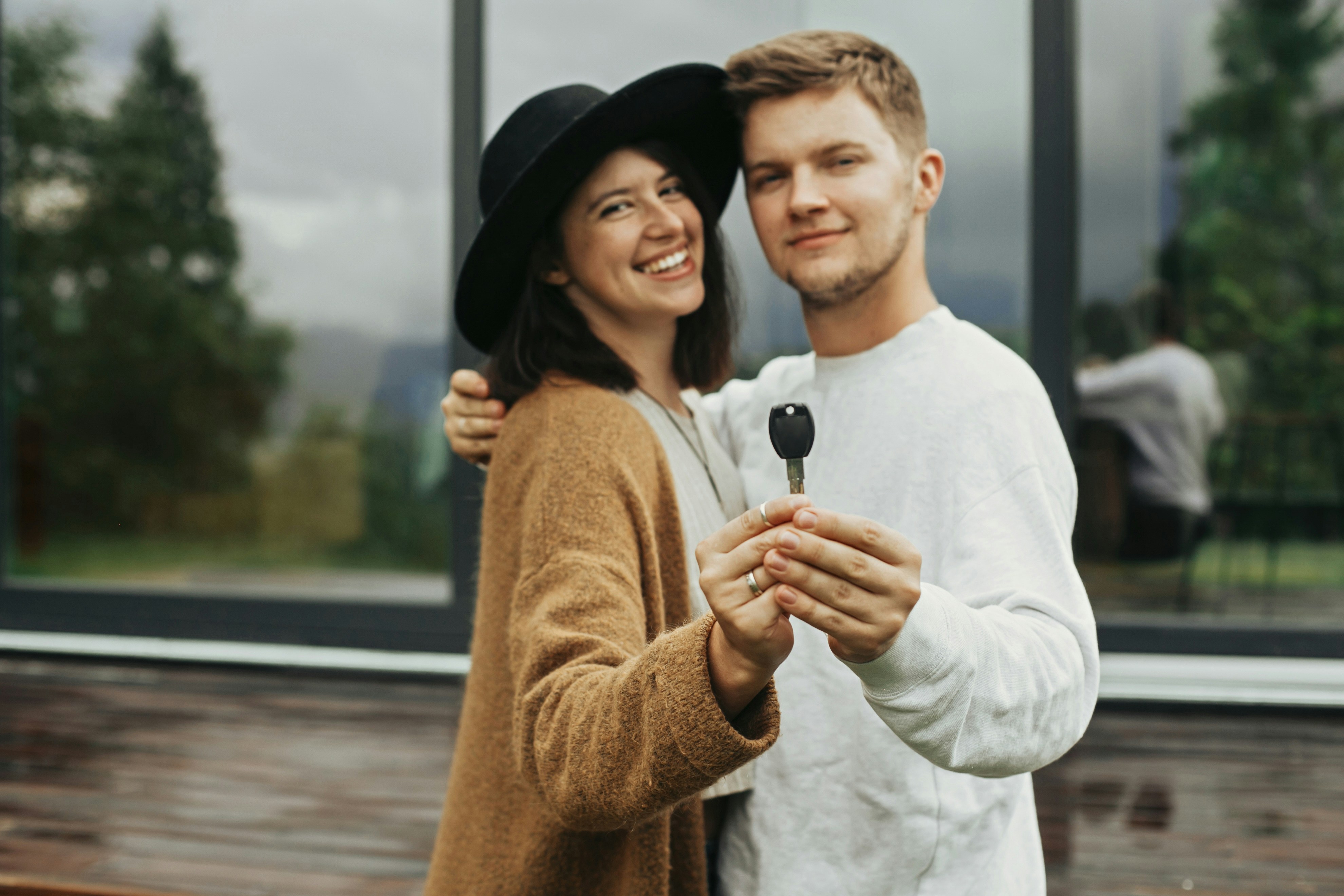 Couple holding a key in front of their new Dutch home