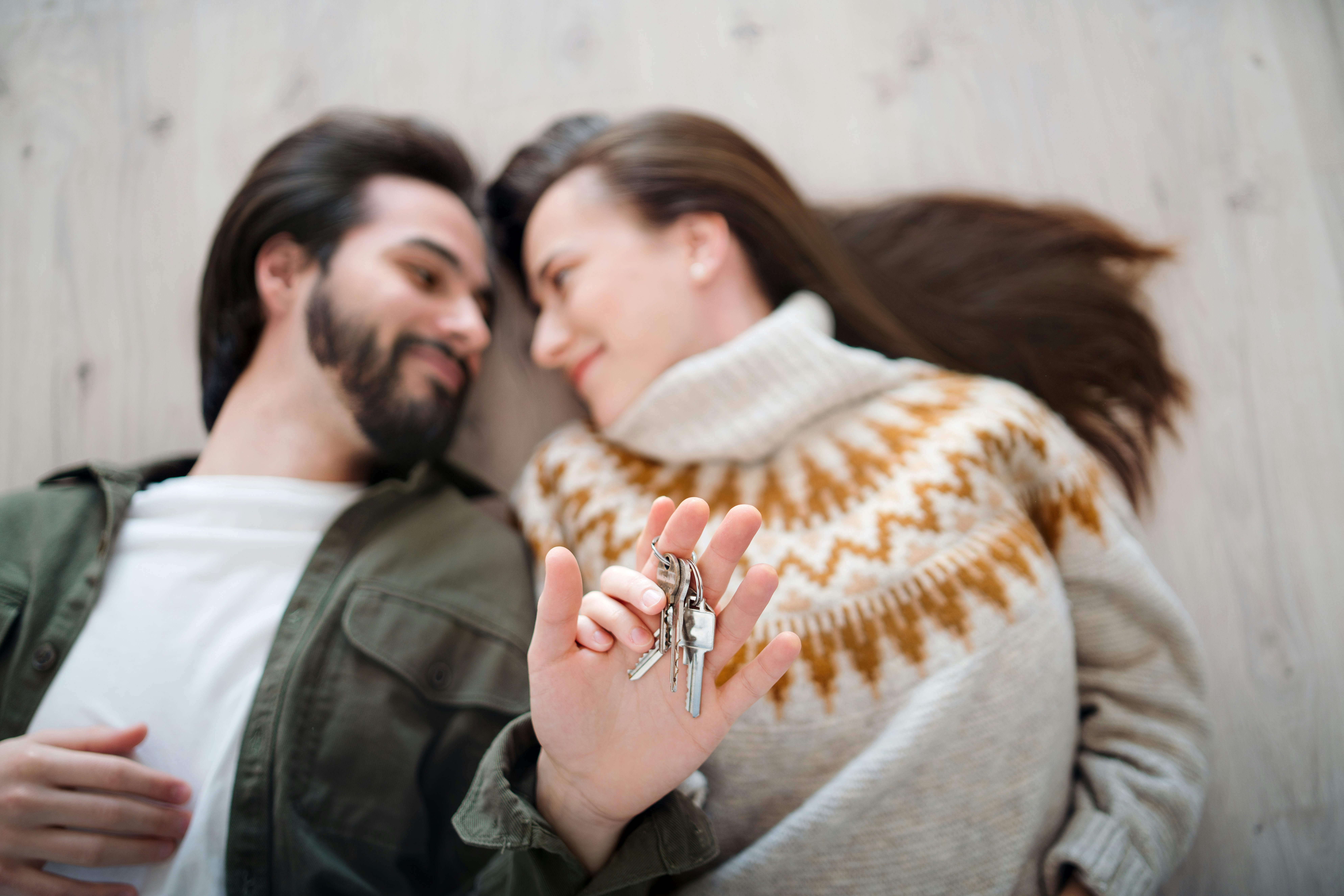Couple lying on the floor with their new house keys